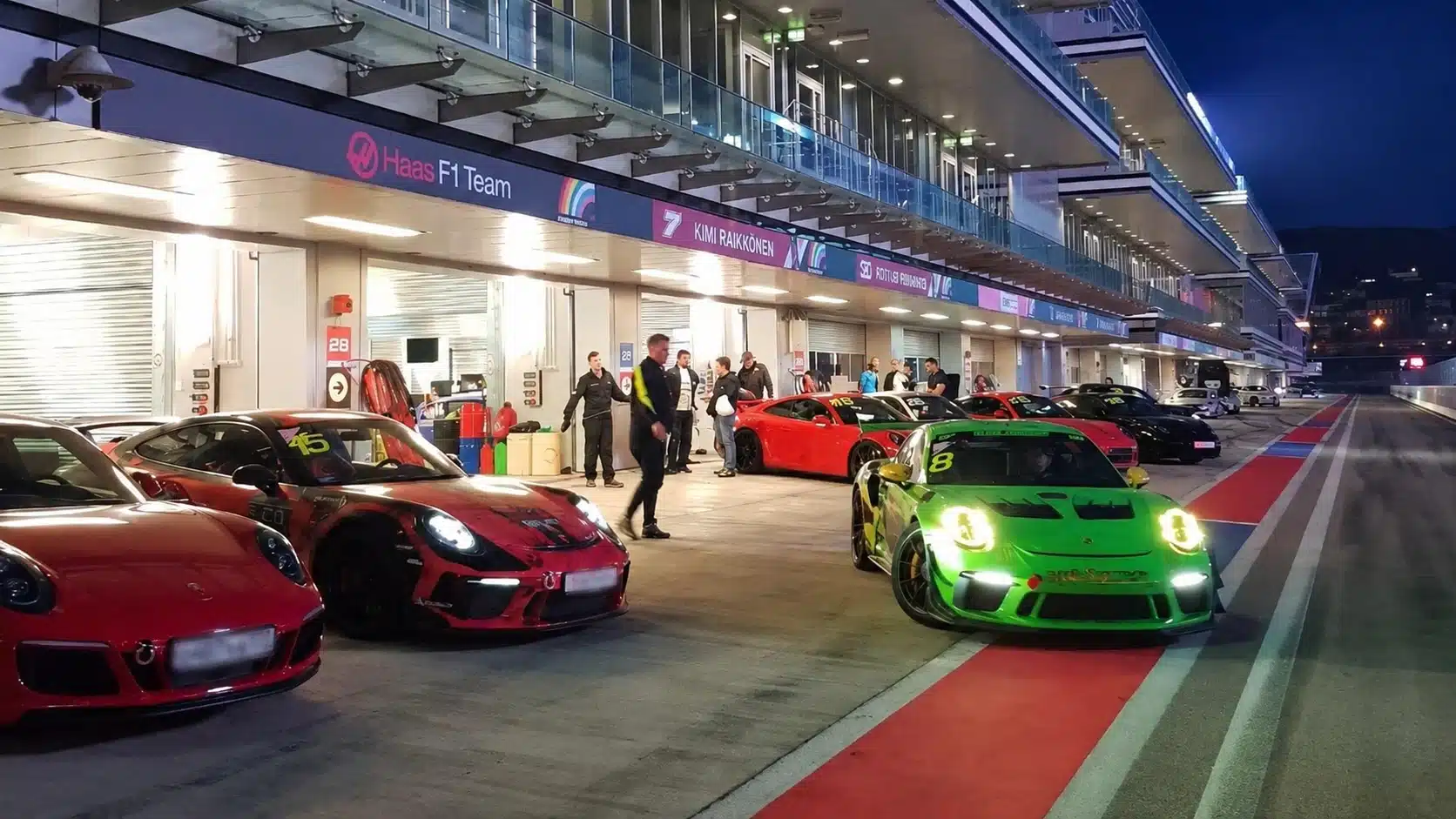 Mehrere Porsche-Rennwagen stehen vor Beginn der Trainingsrunde in der Nähe der Boxen.