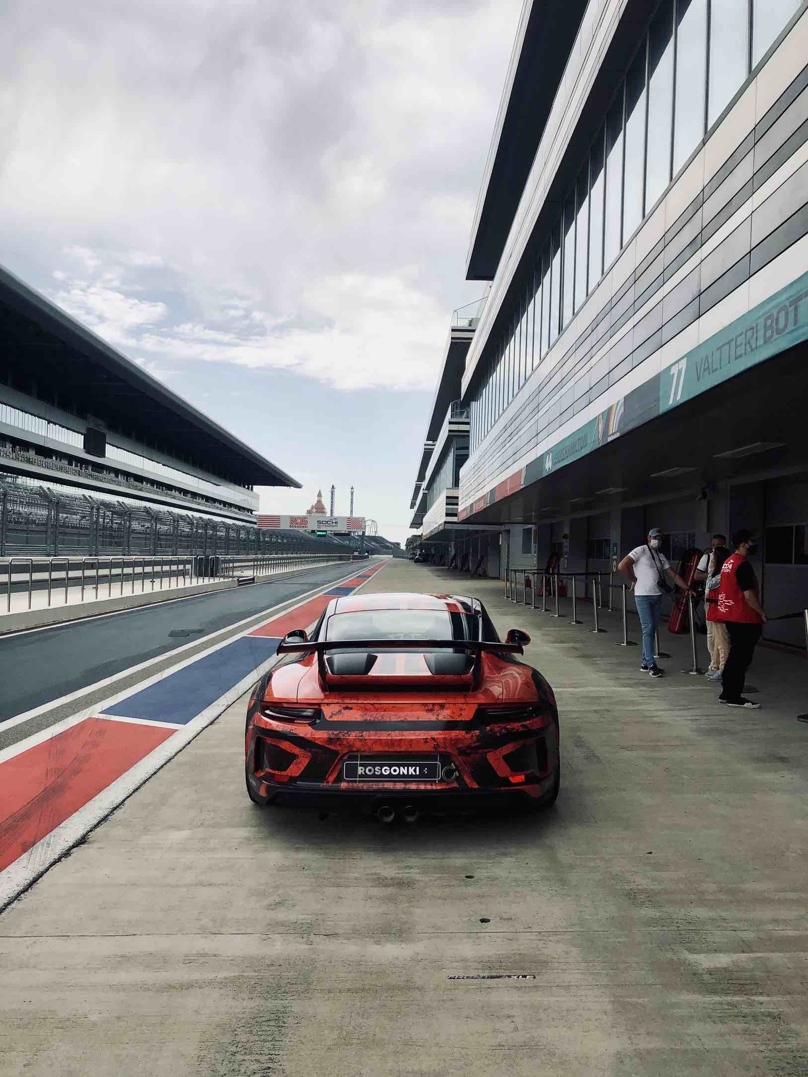 Ein Porsche GT3 steht in der Boxengasse neben den Kunden, bevor er auf die Formel-1-Strecke fährt