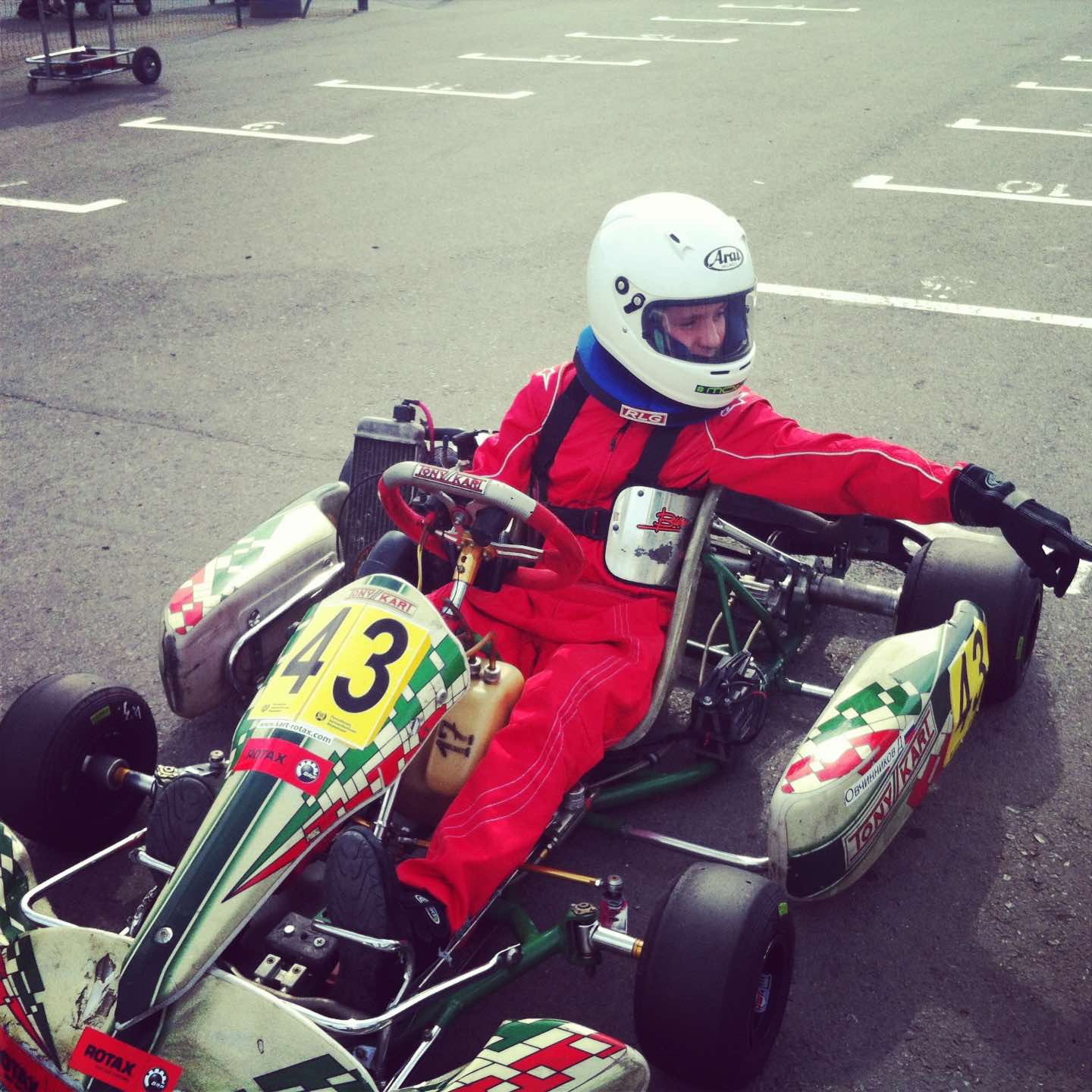 Ich sitze im Kart und absolviere mein erstes Training auf einem professionellen Rotax Max Junior-Kart mit der Startnummer 43 und meinem Nachnamen auf dem Seitenverkleidungsteil