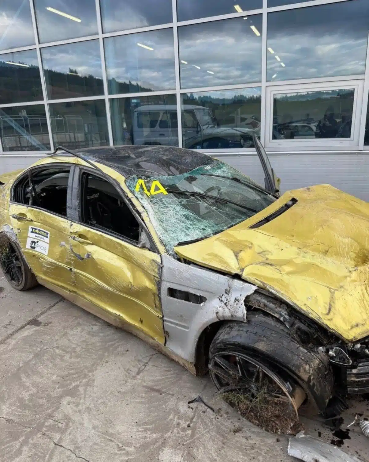 Ein stark beschädigtes gelbes Auto mit der Startnummer 44 nach einem schweren Unfall auf der Rennstrecke: eingedrücktes Dach, eingedrückte Motorhaube, zerbrochene Scheiben.