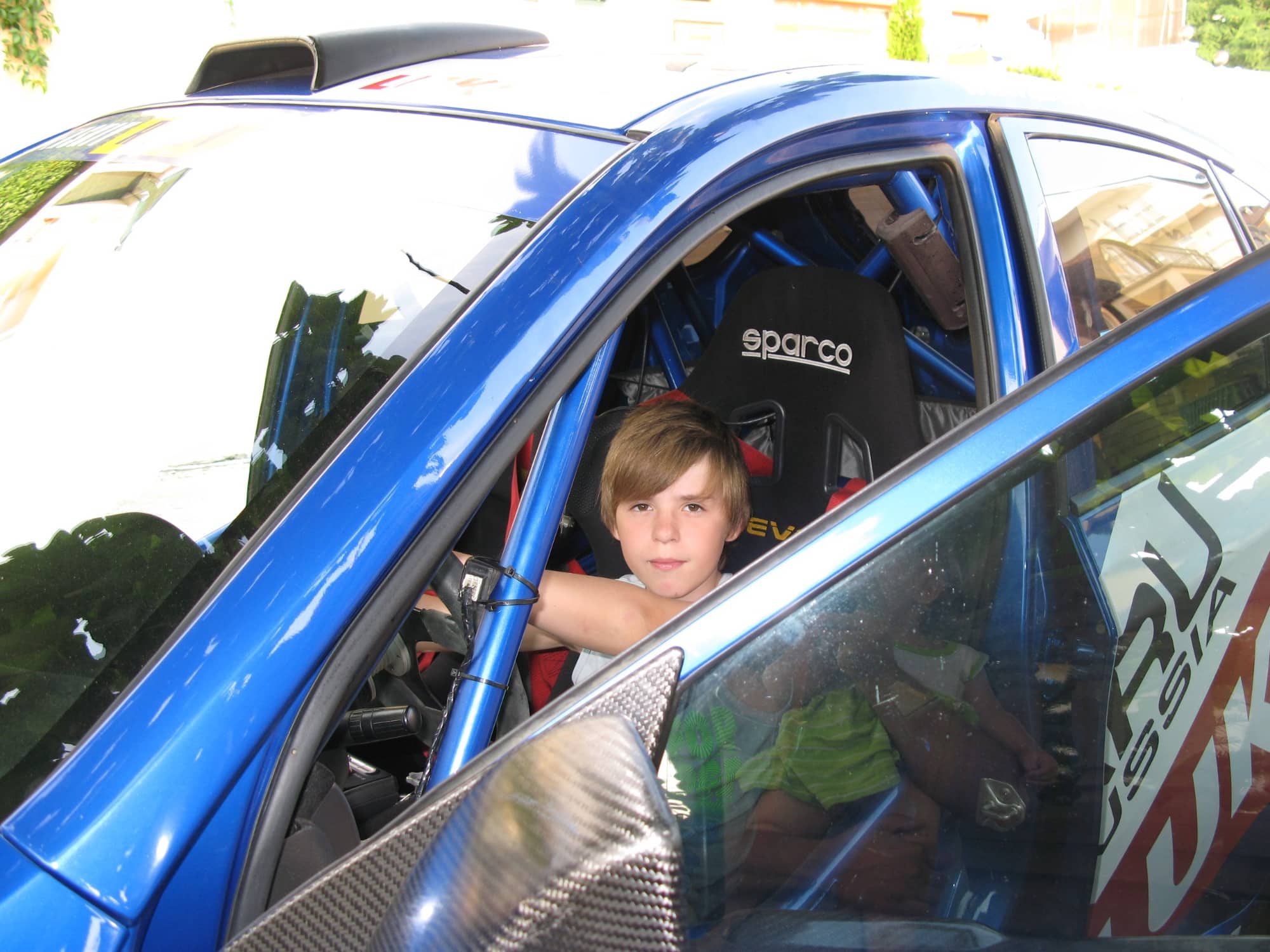 Ein Kinderfoto von mir als angehender Rennfahrer am Steuer eines Sportwagens mit Überrollkäfig