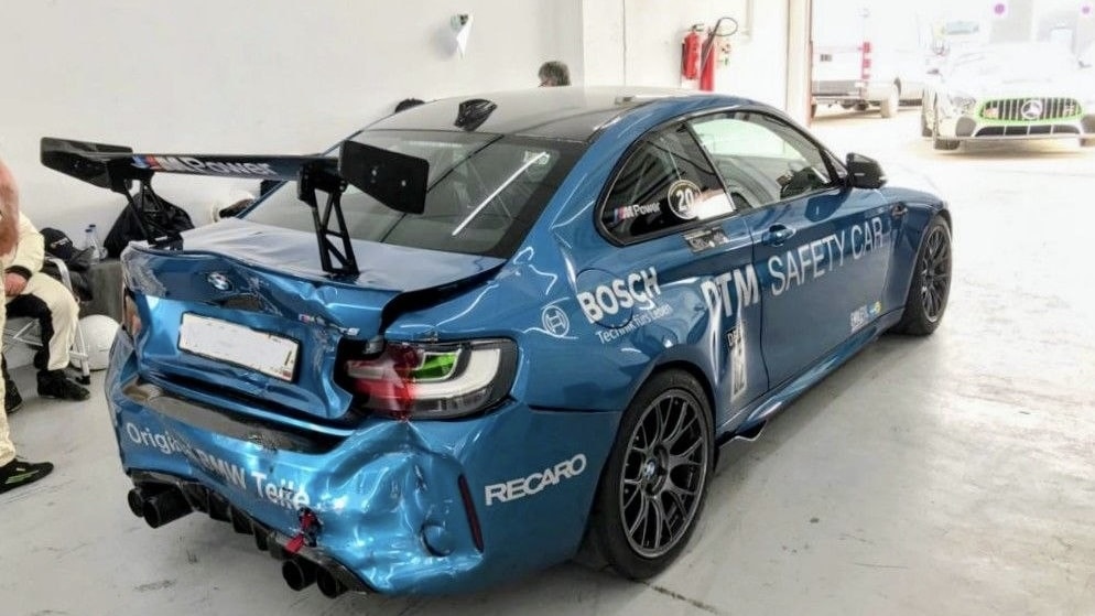 Das beschädigte blaue BMW M2 Safety Car steht nach dem Unfall auf der Rennstrecke in der Box