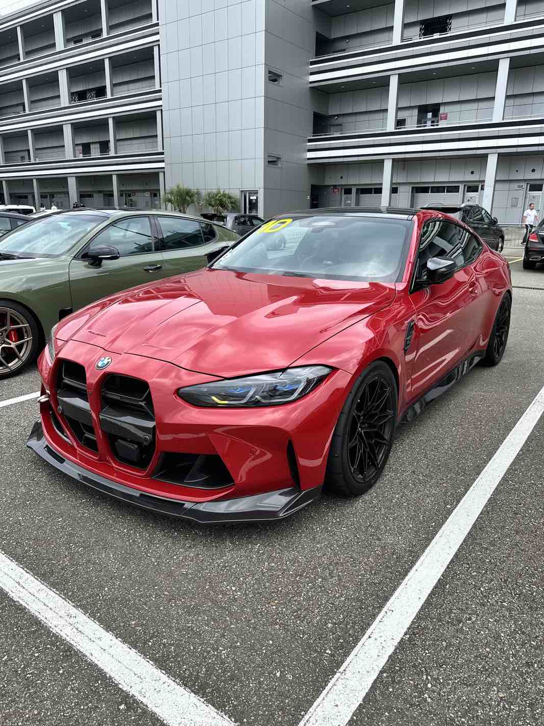 Ein roter BMW M4 Competition G82 auf dem Parkplatz der Rennstrecke