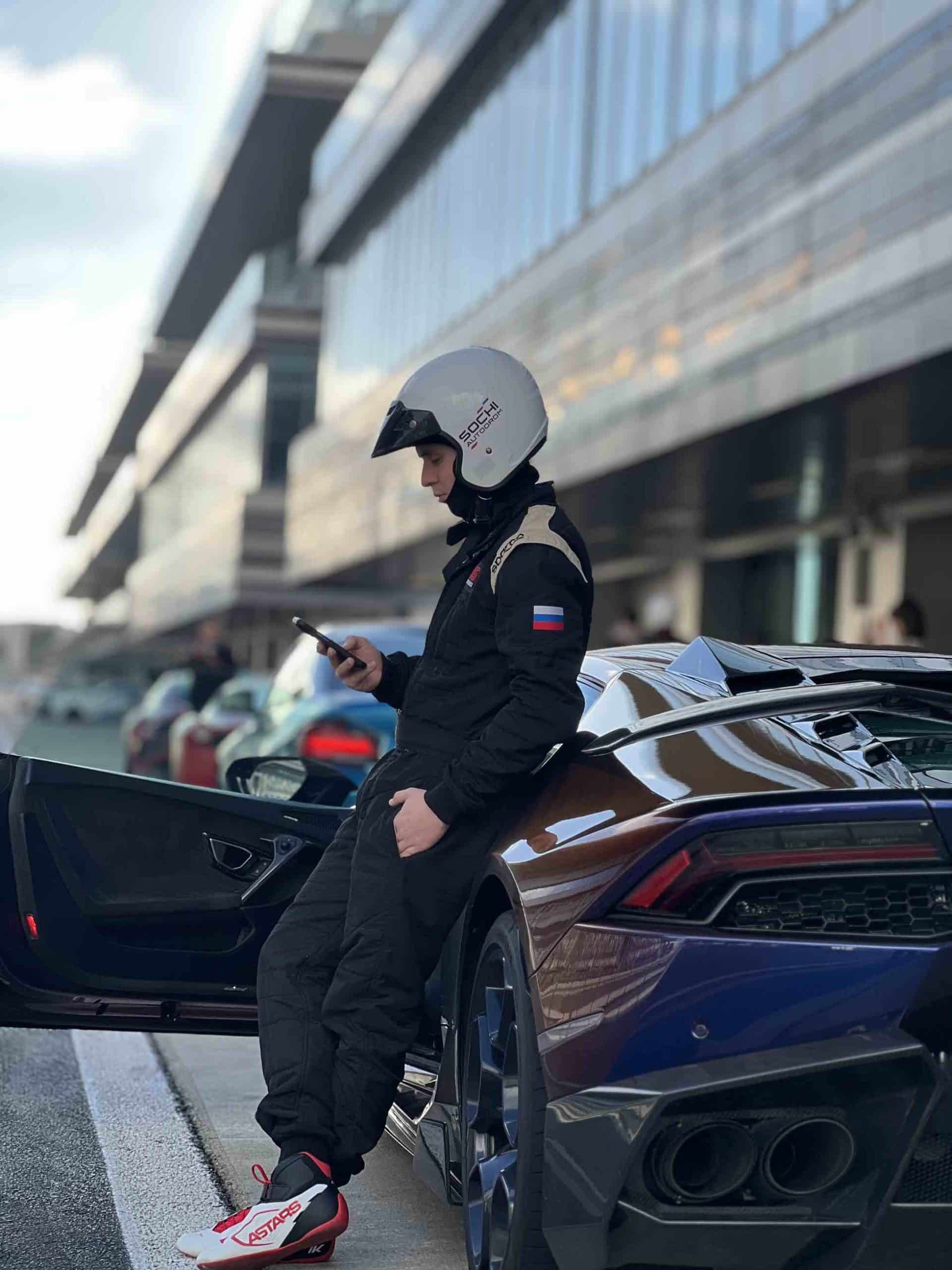 Ich bin Fahrlehrer am Sochi Autodrom vor dem Start und treffe mich mit einem Kunden neben einem Lamborghini Huracan, bevor wir auf die Strecke fahren
