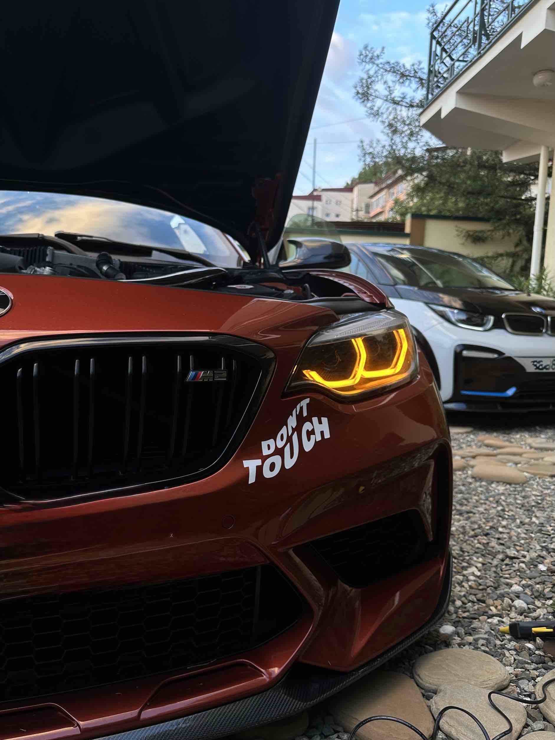 Die Frontpartie des BMW M2 Competition mit Carbon-Motorhaube und orangefarbenen „Engelsaugen“